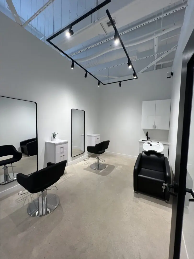 Modern hair salon with chairs and mirrors.